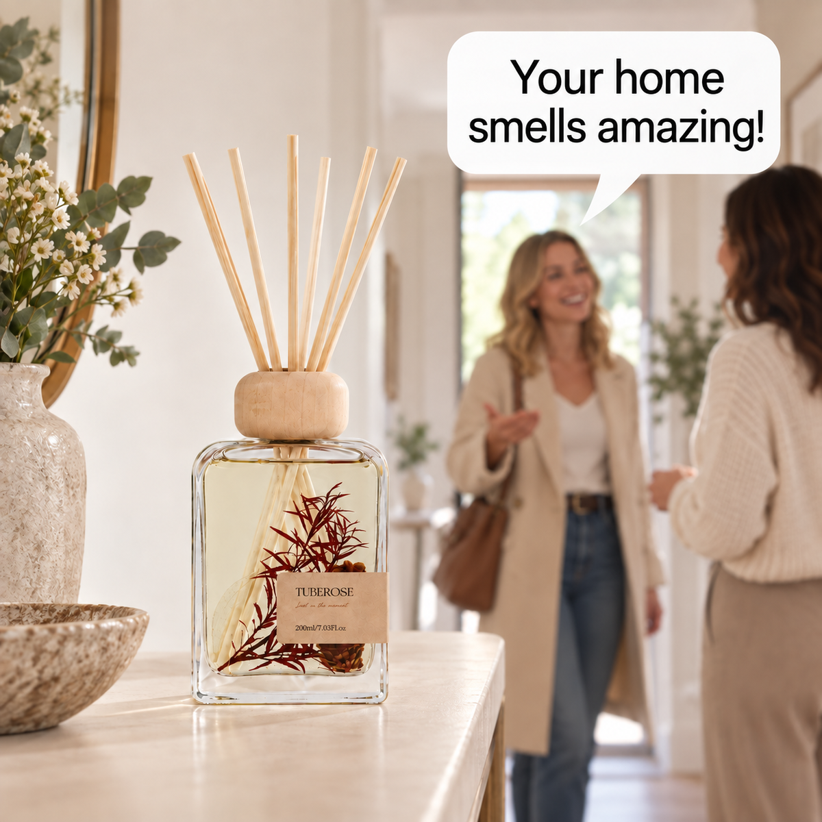 A botanical reed diffuser in a welcoming hallway as a guest compliments the fragrance.