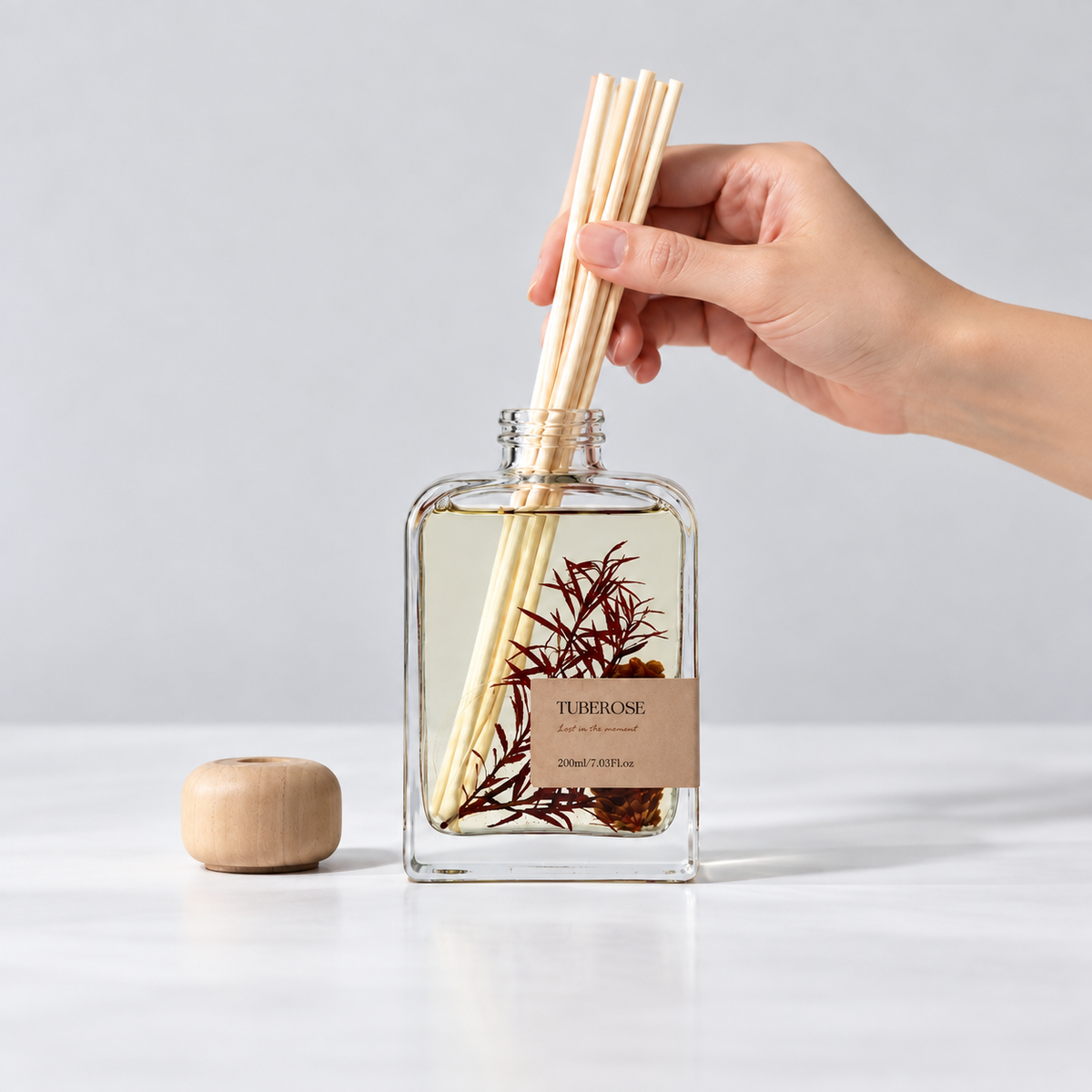 Hands placing reeds into the Momoria diffuser